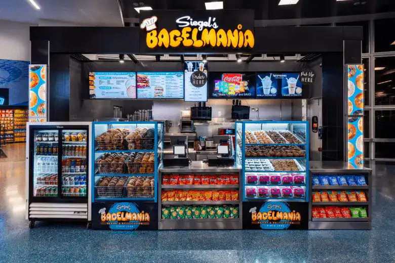 Siegel's Bagelmania deli counter with bagel cases and neon sign